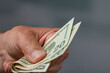 close-up of a man's hand holding a bunch of dollar bills / greenbacks