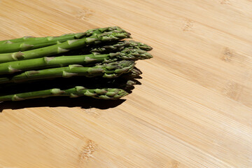 Wall Mural - Green Asparagus on Cutting Board.Pile of fresh, organic, nutritious, green asparagus over a wooden cutting board. Asparagus officinalis.