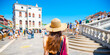 A woman with a hat walking in Venice on a sunny summer and holiday day.