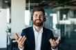 © Prostock-studio - Portrait of happy businessman in headset talking and gesturing at camera, sitting in office interior, copy space
