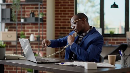 Wall Mural - male secretary answering landline phone call at startup job, having remote conversation with busines
