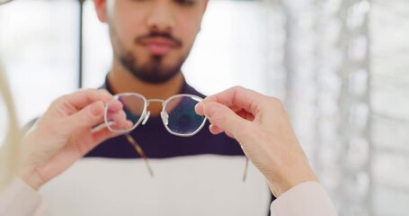 Wall Mural - Optician fitting a pair of glasses on a man in an optical store. Optometrist choosing trendy spectacles from a shelf for customer. Trying on new prescription lenses for vision and eyesight correction