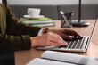 © New Africa - Woman with modern laptop learning at table indoors, closeup
