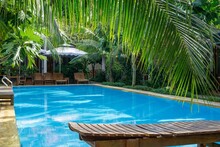 Holz-Sonnenliegen Um Einen Pool In Einer Hotelanlage Mit Villen Auf Der Insel Phu Quoc In Vietnam