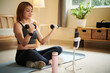 © DragonImages - Fit young woman filming herself doing exercise with dumbbells to strengthen biceps