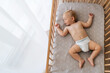 Upper view copy space portrait of cute blond baby sleeping in bed on his back, feeling safe, watching sweet dreams, resting, growing, gaining strength, getting strong. Childcare concept. Nap time