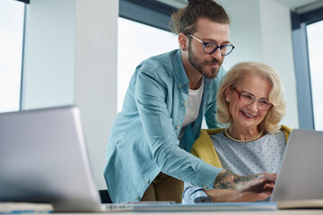 An educator helping female senior student to master the material.