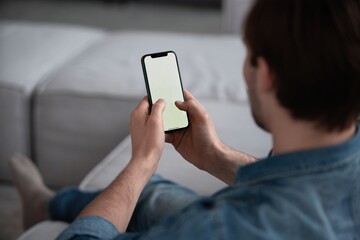 Wall Mural - unrecognizable man using smart phone with white empty screen for mockup, making video call or chatti