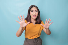 Stop. Concerned Asian Woman Showing Refusal Sign, Saying No, Raise Awareness, Standing Over Blue Background
