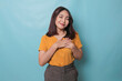 © Reezky - Happy mindful thankful young woman holding hands on chest smiling isolated on blue background feeling no stress, gratitude, mental health balance, peace of mind concept.