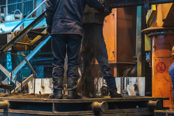 Wall Mural - Workers work with molds for smelting iron at steel mill in factory workshop.