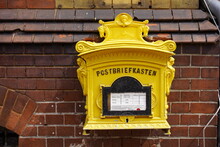 Old, Yellow Post Box (in German: Postbriefkasten And The Emptying Times) In The Hanseatic City Of Salzwedel. Saxony Anhalt, Germany.