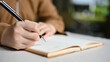 © bongkarn - A female college student writing her homework on a school notebook. Close-up and focus hand