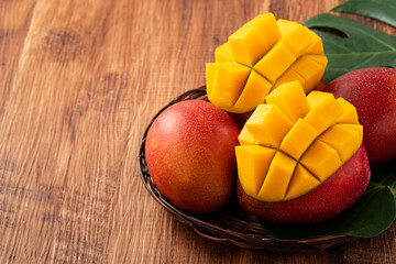 Mango. Fresh mango fruit with leaves over dark wooden table background.