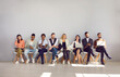 © Studio Romantic - Group of multiracial people are waiting their turn for interview sitting on chairs in row. People with paper documents, resumes, laptops and mobile phones are sitting in line in personnel department.