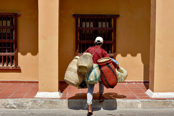 Young man sells straw baskets to store the family's clothes.