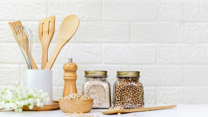 Kitchen tools and kitchenware utensil object with ingredients and mix nut on kitchen shelf wood white for healthy eat and health care life.  Wall white brick background, copy space for text