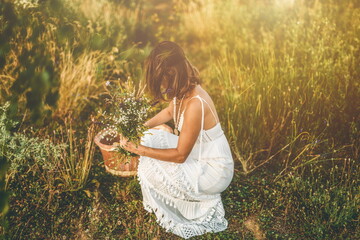 Woman collects beautiful spring flowers in a summer day.