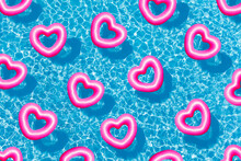 Pool With Many Pink Buoys Floating Of Heart Shape From Above