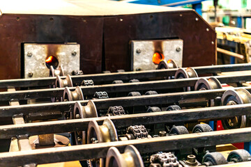 Rolls of an industrial machine for cutting metal. Conveyor line in a factory for processing sheet steel. Close-up of production equipment.