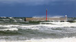 Duża morska fala rozbija się o falochron na wybrzeżu