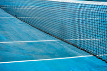 Close-Up Of A Tennis Net On A Blue Tennis Court