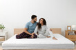 © New Africa - Happy couple on bed with comfortable mattress at home