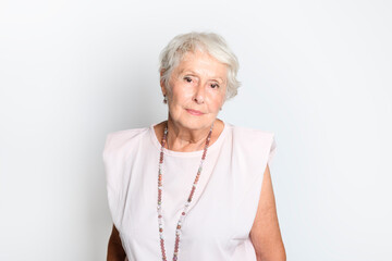 Wall Mural - smiling retired senior woman looking at camera isolated on white background