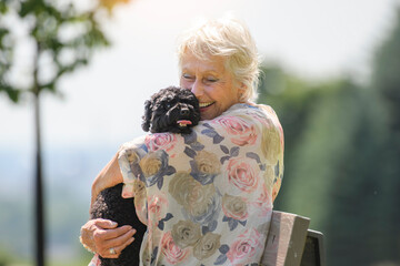 Wall Mural - Senior Woman with Pet Dog outside in nature with poodle