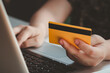 © Achira22 - Credit card payment. Woman hands holding credit card and using laptop. Online shopping