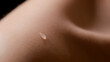 © pavel_dp - Macro shot of water drop on bare shoulder of white-skinned female model on black background | Skin texture shot for skincare serum commercial