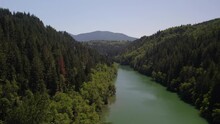 Drone Footage Over The Nisqually River In A Forest Of Evergreen Trees Near Le Grande Dam.