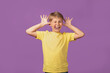 © Iryna Dincer - Young blond Caucasian kid preteen boy making faces staying against purple background. Studio shot.