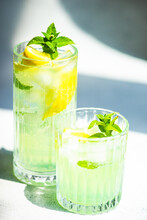 Close-Up Of Two Mojito Cocktails On A Table With Fresh Mint And Lemon