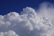 Riesige weiße Quellwolke im heißen Sommer vor azurblauem Himmel. Entwickelt sich daraus eine Gewitterwolke? Ausschnitt, Querformat.