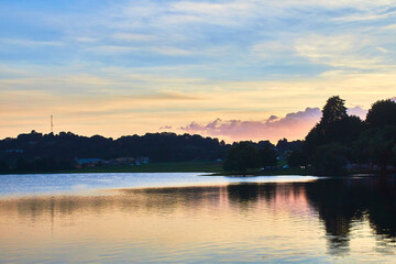 Wall Mural - lake at sunset with amazing colors in the sky yellow blue and purpple some clouds and mountains in the background 