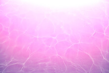 Defocus Blurred Pink Water Shining In The Sea. Rippled Water Detail Background. The Water Surface In The Sea, Ocean Background. Water Wave Under Sea Texture Background.