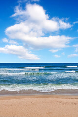  Beautiful, calm and quiet view of the beach, ocean and seashore against a cloudy blue sky on a summer day. Peaceful and remote ocean and sea with waves rolling into the shore in a natural environment