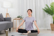© Pichsakul - Yoga exercise concept, Young Asian woman with close eyes and meditation doing yoga training online