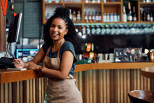 Happy African American Waitress At Bar Counter In Cafeteria Looking At Camera.
