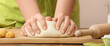 Baker kneading dough on table, closeup