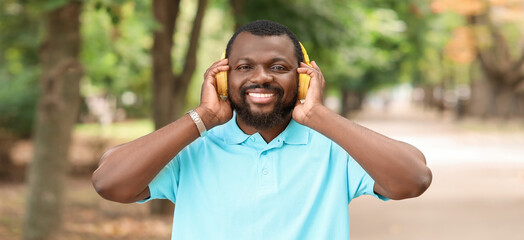 Canvas Print - Handsome African-American man listening to music in park