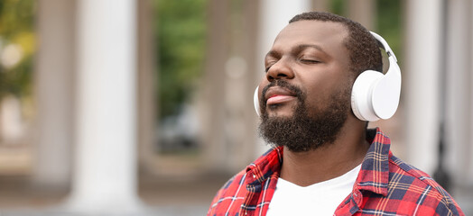 Canvas Print - Handsome African-American man listening to music outdoors