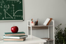 Red Apple With School Books On Table In Classroom
