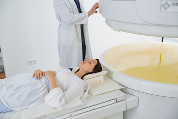 Wall Mural - Woman patient is ready to do magnetic resonance imaging MRI or CT scan in clinic