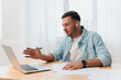 © SHOTPRIME STUDIO - Smiling happy friendly good-looking young businessman conducts a job interview remotely using laptop in office. Copy space for ad. Remote Job, Technology And Career Profession Concept