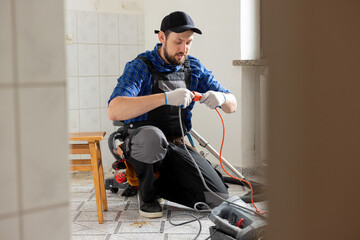 Wall Mural - Connecting cables with a plug, extension cord plugging in construction equipment, breakdown, short circuit in house during renovation experienced man in field of electricity repairs electrical.