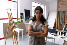 Image Of Serious Biracial Female Artist Looking At Camera In Studio