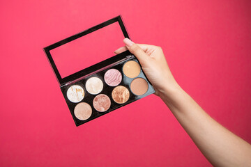 makeup artist showing eyeshadow palette.