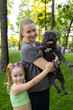 © Roman - mother with daughter in the park mother holding a french bulldog in her arms